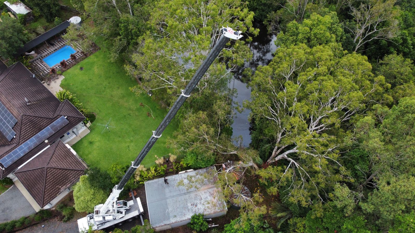 Aerial view of crane removal over a backyard pool